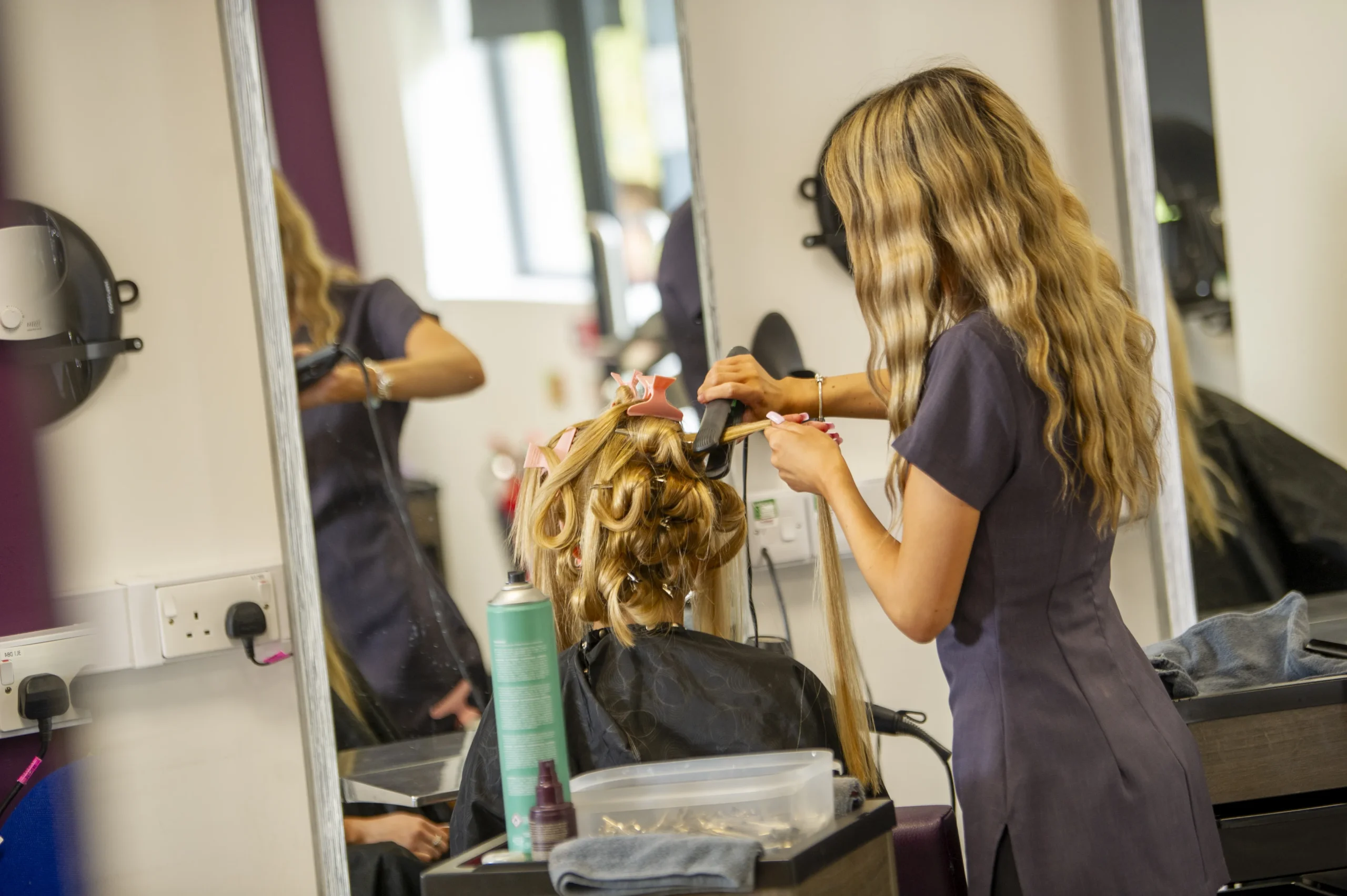Student cutting a clients hair